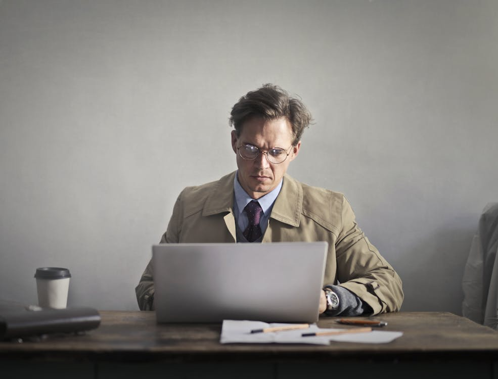 Image of John, a 40-year-old homeowner, frustrated while reviewing financial documents on his laptop, illustrating the inconvenience of managing documents manually without a centralized system or digital command center.