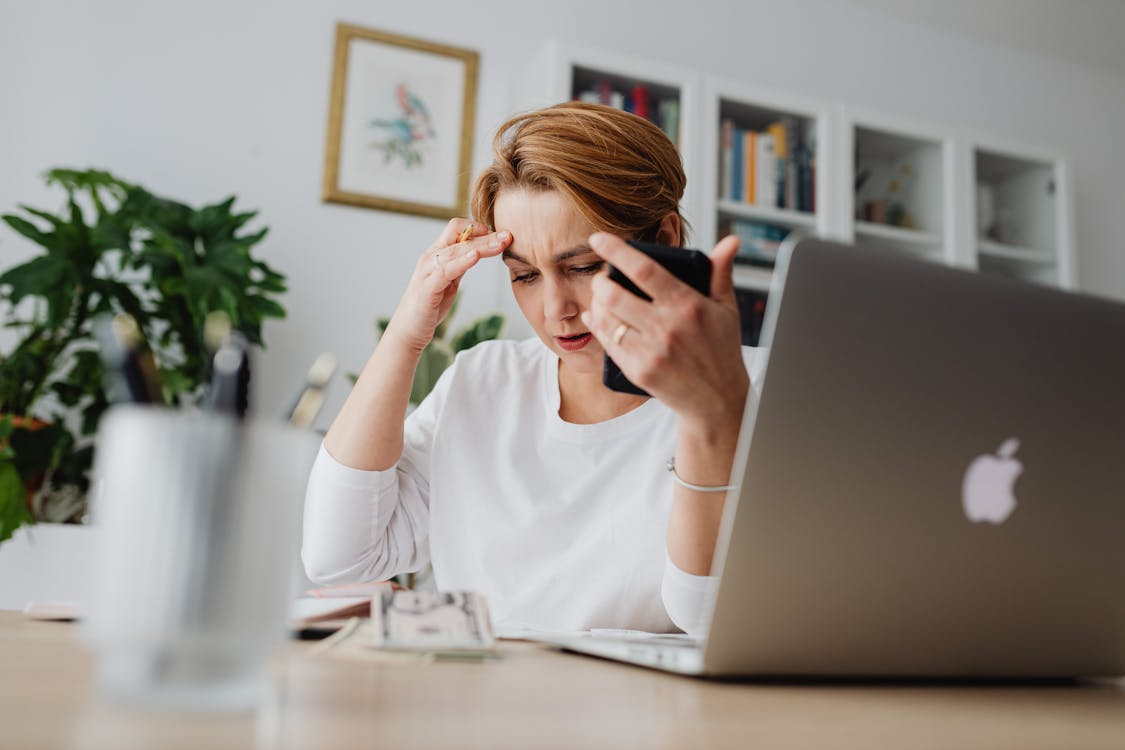 An overwhelmed homeowner is managing scattered tax documents with a home maintenance app during tax season.